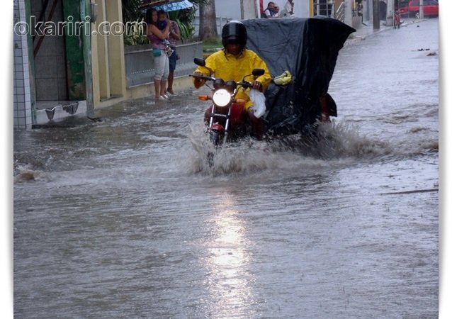 Motociclista atravessa com água cobrindo boa parte da moto| Foto: Agência OKariri