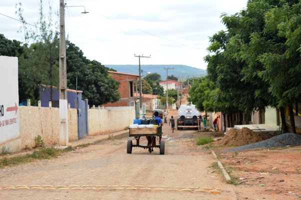A frente uma “carrada” de água comprada pelos moradores, ao fundo o carro pipa do Pac 2 abastece as casas | Foo: Agência OKariri